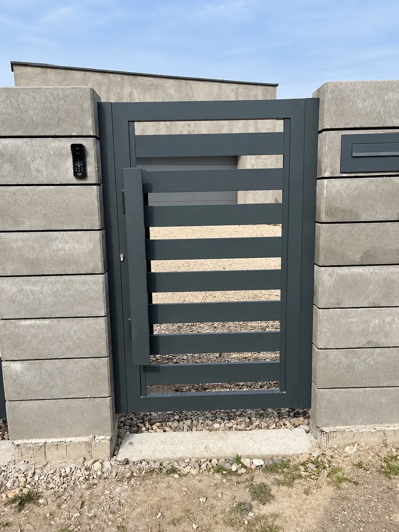 Furtka z poziomymi profilami i antabą między betonowymi słupkami